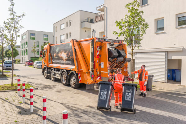 Bild vergr&ouml;&szlig;ern: Müllwerker bei der Abfalltonnenentleerung.